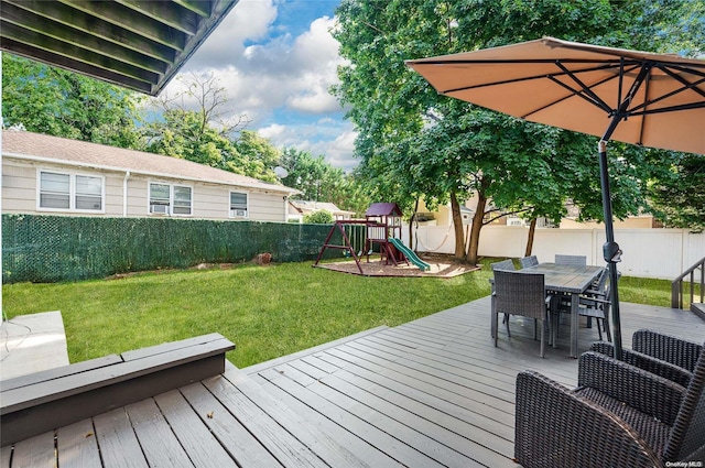 wooden terrace featuring a playground and a yard