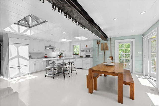 dining space featuring beamed ceiling