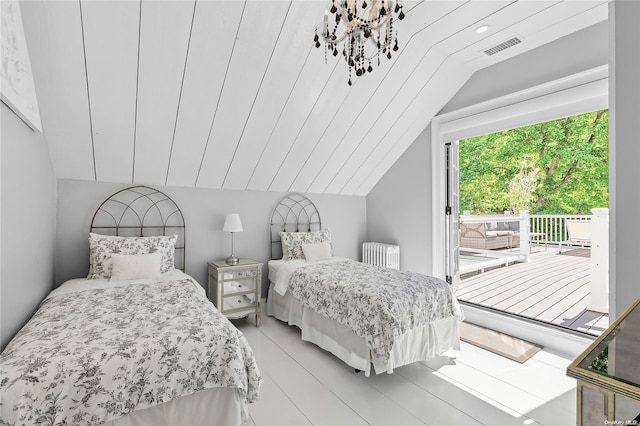 bedroom featuring light wood-type flooring, vaulted ceiling, and radiator