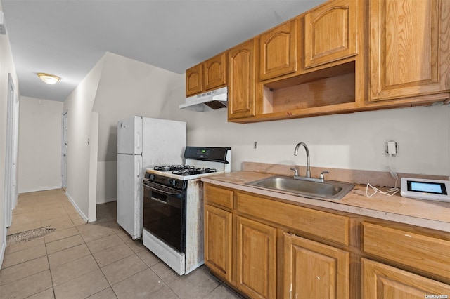 kitchen featuring white range with gas stovetop, sink, and light tile patterned floors