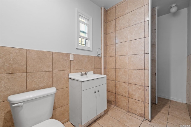 bathroom with tile patterned flooring, vanity, tile walls, and toilet