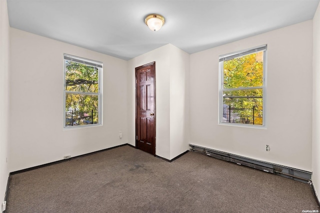 empty room featuring carpet floors and a baseboard heating unit