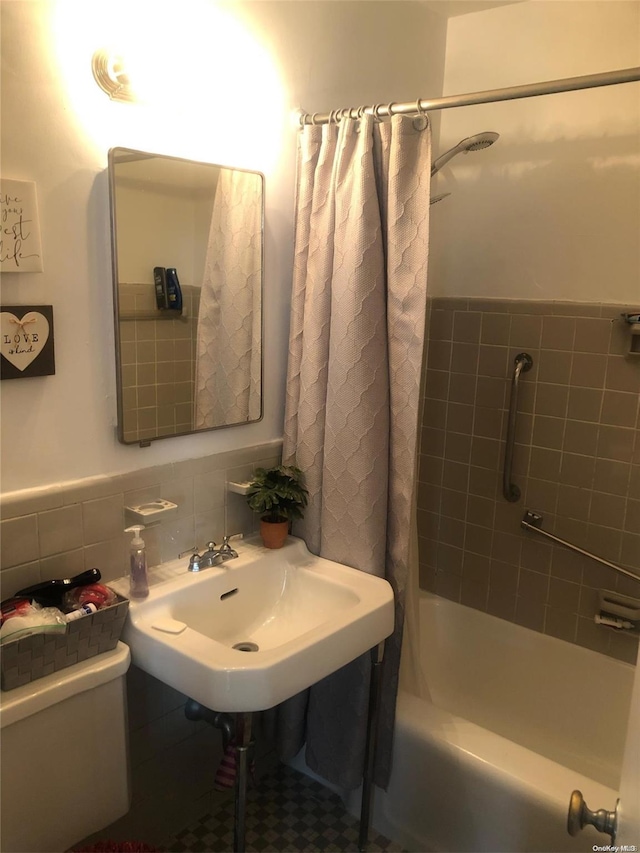 full bathroom with shower / tub combo, toilet, tile walls, and sink