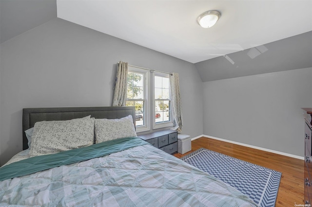 bedroom with hardwood / wood-style floors and lofted ceiling