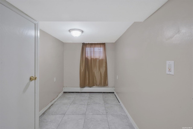 tiled spare room featuring a baseboard radiator