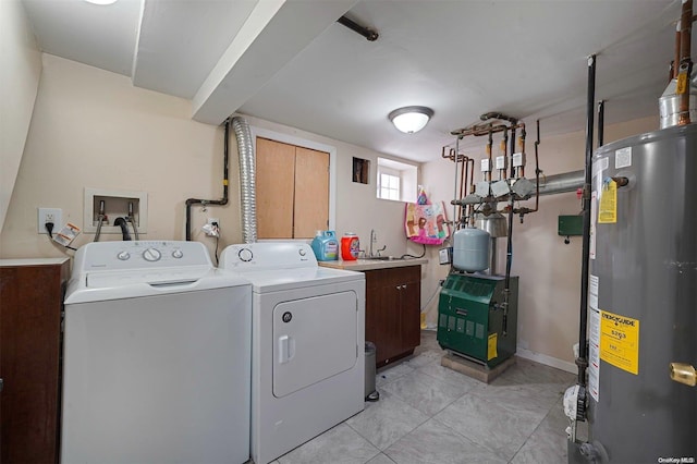 laundry area featuring sink, cabinets, water heater, light tile patterned floors, and washer and dryer