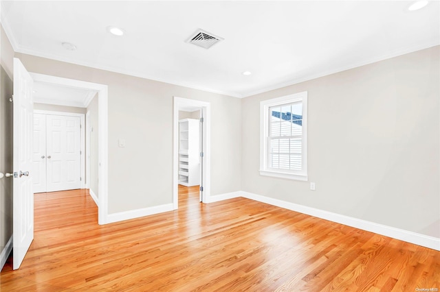 unfurnished room featuring crown molding and light wood-type flooring