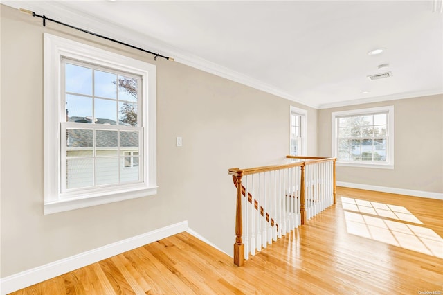 hall featuring hardwood / wood-style floors, plenty of natural light, and ornamental molding