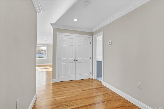 corridor featuring light wood-type flooring and crown molding