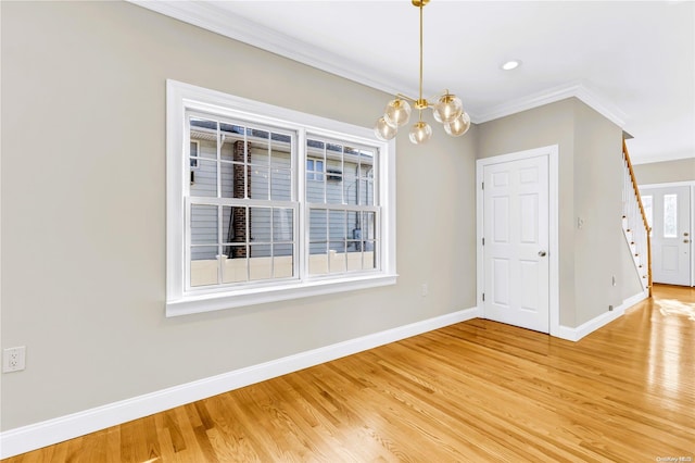 unfurnished room with a chandelier, hardwood / wood-style floors, and crown molding