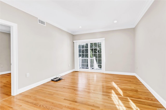 spare room featuring crown molding and hardwood / wood-style flooring