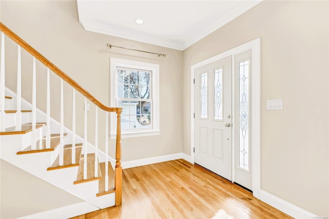 foyer with ornamental molding and hardwood / wood-style flooring