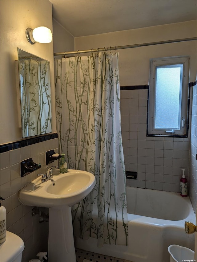 bathroom featuring shower / bathtub combination with curtain, toilet, and tile walls