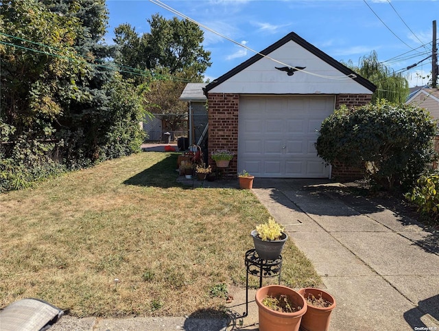 view of side of property with a lawn, a garage, and an outbuilding