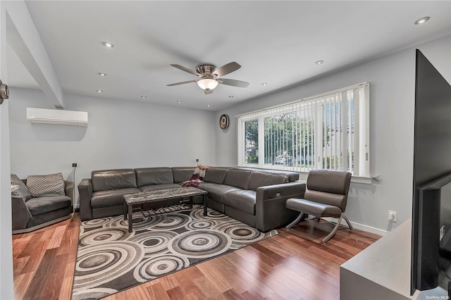 living room featuring hardwood / wood-style floors, an AC wall unit, and ceiling fan