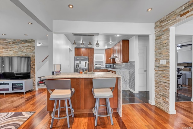 kitchen with stainless steel refrigerator with ice dispenser, light wood-type flooring, tasteful backsplash, ceiling fan, and sink