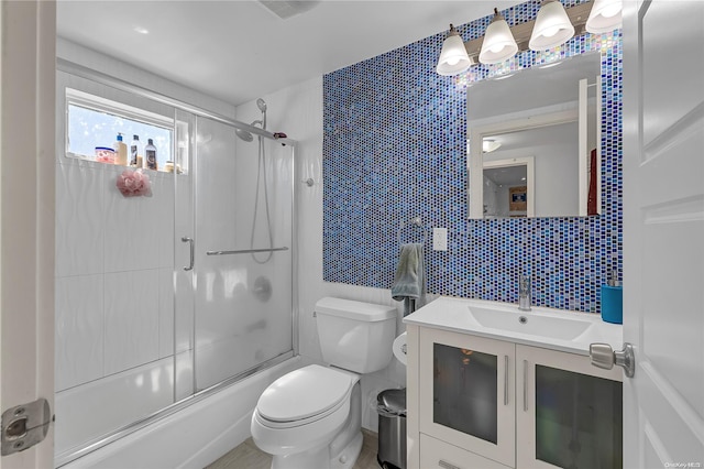 full bathroom with decorative backsplash, vanity, shower / bath combination with glass door, tile walls, and toilet