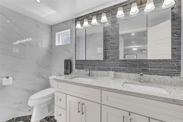 bathroom with vanity, backsplash, toilet, and tile walls