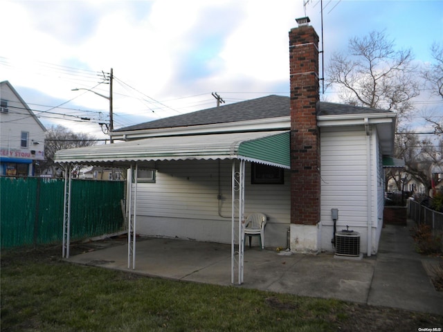 rear view of house featuring central AC unit and a patio area