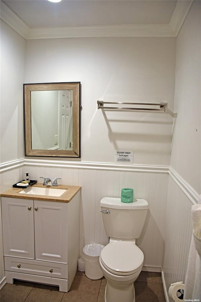 bathroom with tile patterned flooring, vanity, toilet, and crown molding