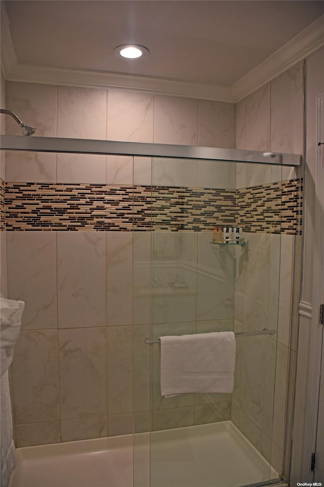 bathroom featuring ornamental molding and walk in shower