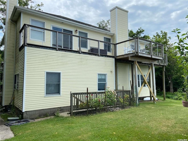 rear view of house with a balcony and a lawn