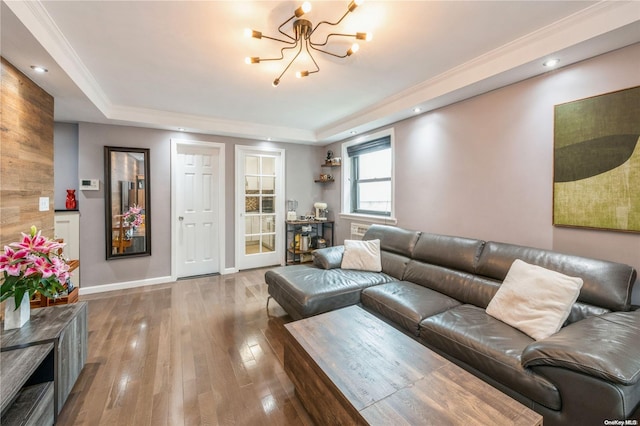 living room featuring a chandelier, hardwood / wood-style floors, and a raised ceiling