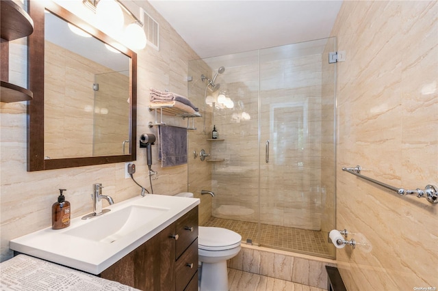 bathroom with walk in shower, toilet, decorative backsplash, vanity, and tile walls