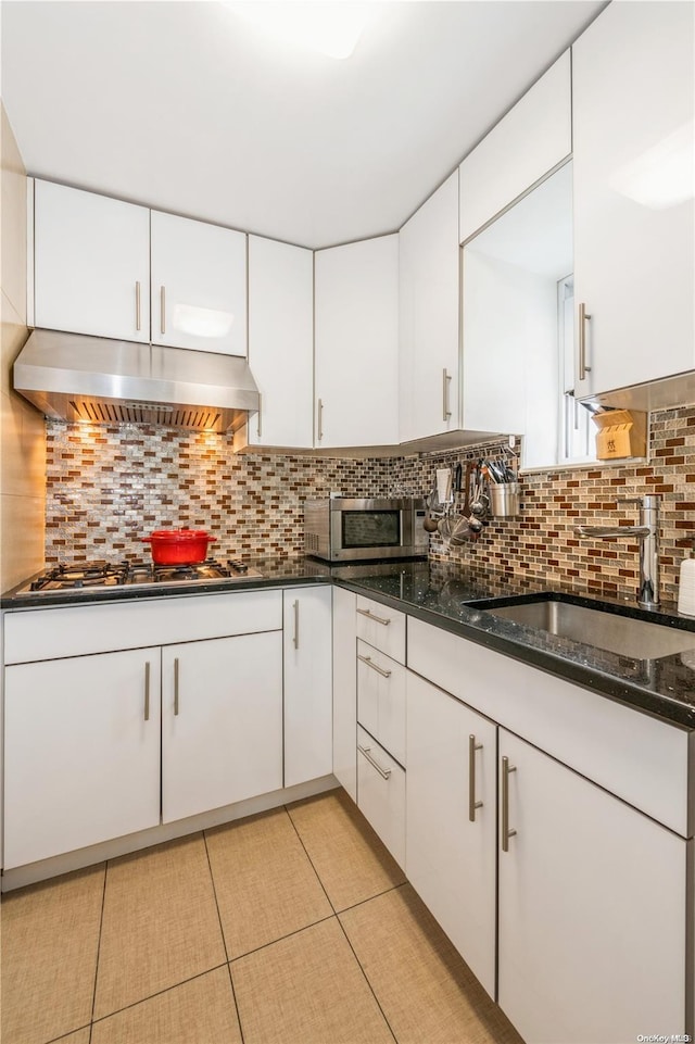 kitchen with tasteful backsplash and white cabinetry