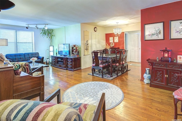 living room with a notable chandelier and light wood-type flooring