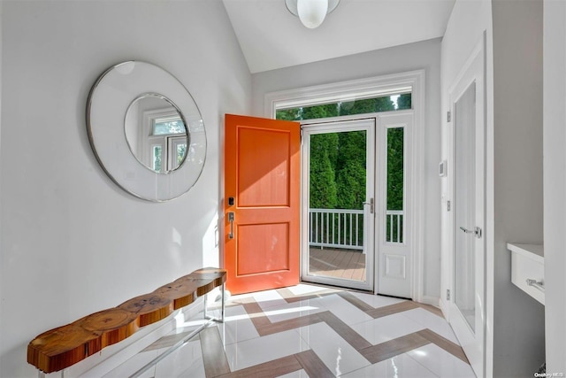 tiled entrance foyer featuring vaulted ceiling