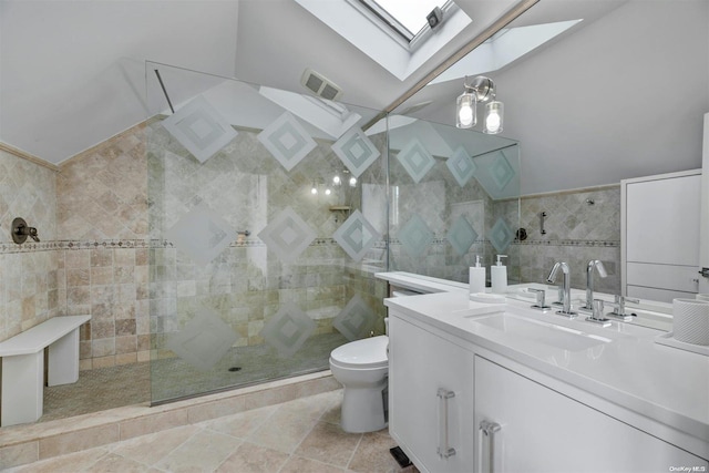 bathroom with a tile shower, tile patterned floors, and tile walls