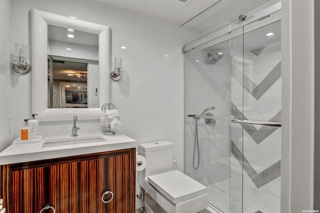 bathroom featuring vanity, toilet, walk in shower, and tile walls