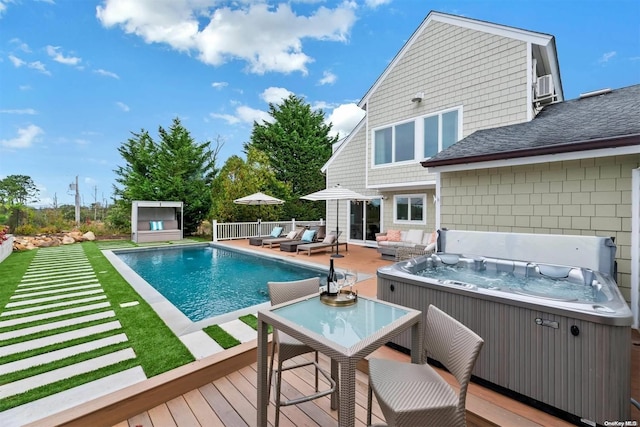 view of swimming pool with a wooden deck and a hot tub