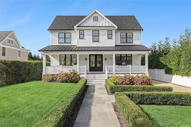 modern farmhouse style home featuring a porch, a front yard, and french doors