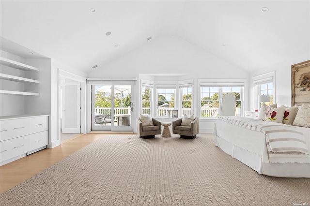 bedroom featuring multiple windows, access to exterior, high vaulted ceiling, and light wood-type flooring