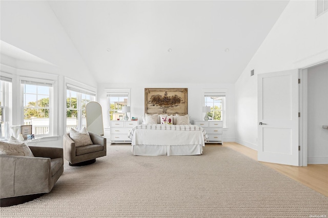 bedroom featuring light hardwood / wood-style flooring and high vaulted ceiling