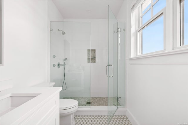 bathroom featuring tile patterned floors, a shower with door, vanity, and toilet