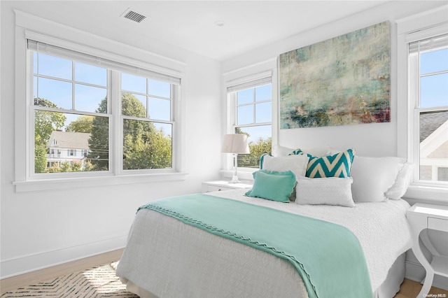 bedroom featuring hardwood / wood-style floors and multiple windows