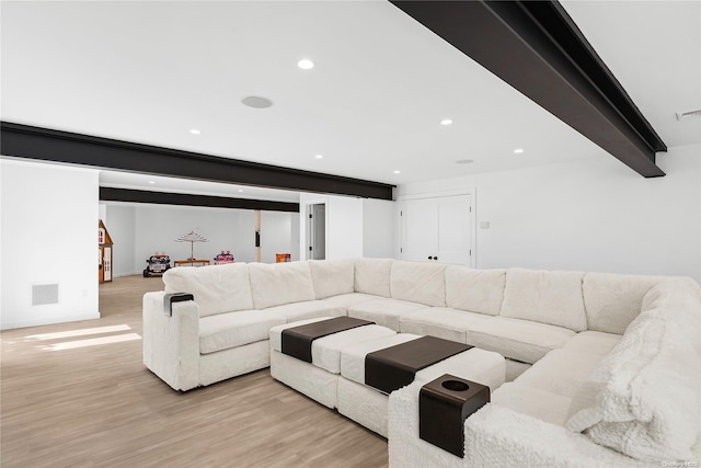 living room featuring light hardwood / wood-style flooring and beamed ceiling