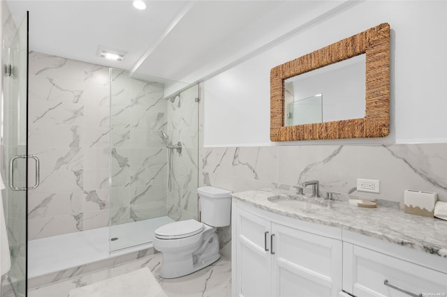 bathroom with vanity, toilet, tile walls, and a shower with shower door