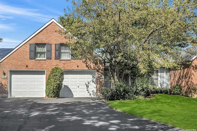 71 Standish Dr Unit 71, Mount Sinai, NY 11766 - view of front of home featuring asphalt driveway, brick siding, a garage, and a front lawn