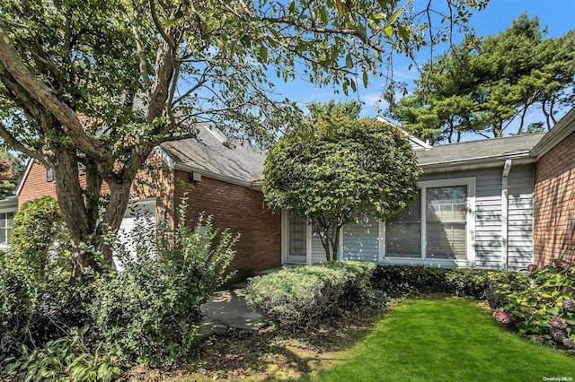 71 Standish Dr Unit 71, Mount Sinai, NY 11766 - view of side of home with a lawn, brick siding, and a shingled roof