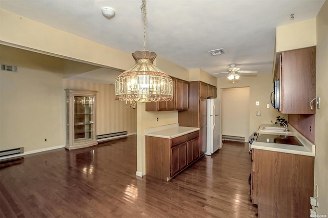 kitchen with hanging light fixtures, a baseboard radiator, dark wood-type flooring, white refrigerator, and ceiling fan with notable chandelier