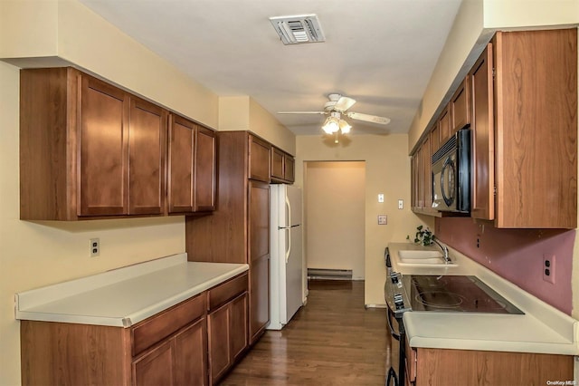 kitchen featuring dark hardwood / wood-style flooring, ceiling fan, a baseboard heating unit, sink, and white fridge