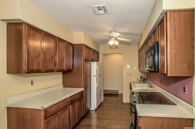 71 Standish Dr Unit 71, Mount Sinai, NY 11766 - kitchen with black microwave, a ceiling fan, a baseboard heating unit, freestanding refrigerator, and light countertops