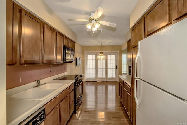 71 Standish Dr Unit 71, Mount Sinai, NY 11766 - kitchen featuring black appliances, brown cabinets, light countertops, and pendant lighting