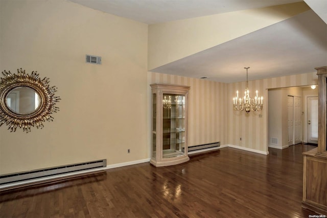 spare room featuring a notable chandelier, dark hardwood / wood-style flooring, and a baseboard heating unit