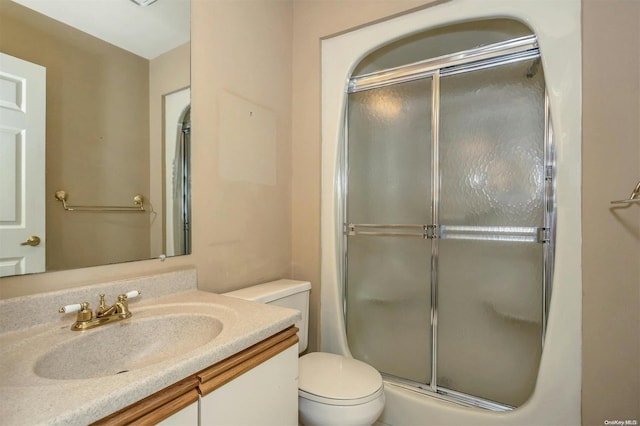 bathroom featuring vanity, an enclosed shower, and toilet