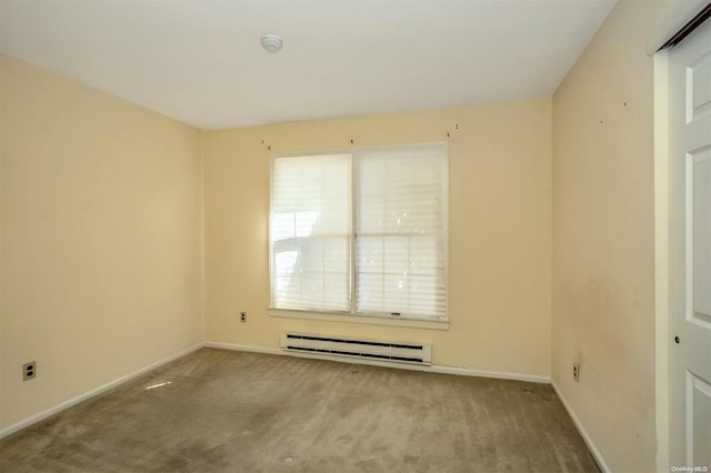 spare room featuring light colored carpet and a baseboard heating unit